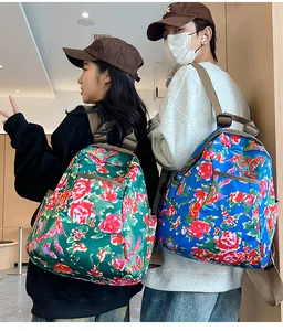 Detail of floral printed backpack showing red rose patterns and durable nylon straps