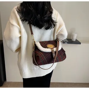 Detail of wool plaid shoulder bag with soft fleece trim and elegant golden hardware