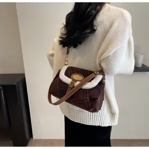 Close-up of retro plaid underarm bag with white fuzzy trim and elegant golden logo plate