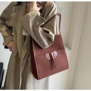 Close-up of caramel brown tote bag featuring a unique elephant shaped front pocket design
