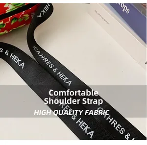 Nahaufnahme des breiten Nylon-Schultergurts mit Text und geblümter gesteppter Tasche