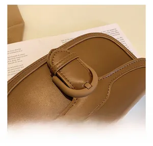 Détail d'un sac en cuir marron avec coutures fines et boucle en cuir décorative élégante