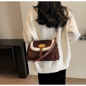 Close-up of retro plaid shoulder bag with white faux shearling trim and gold metal logo