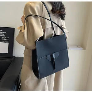 Detail view of the black leather tote bag featuring a unique elephant shaped pocket design
