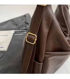 Detailed shot of the golden adjustable buckle and brown leather strap on a bucket bag