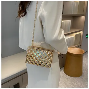 Detailansicht der goldenen Abendtasche mit Perlenkette und funkelnden Strasssteinen