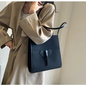 Detail of black matte tote bag with unique elephant leather patch and slender shoulder straps