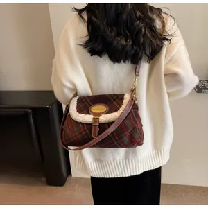 Detail of vintage plaid shoulder bag featuring faux shearling trim and golden metal plaque