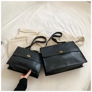 Detail showing two sizes of black faux leather tote bags with vintage gold twist locks