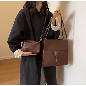Detail view of brown leather tote and elephant crossbody bag with matte texture finish