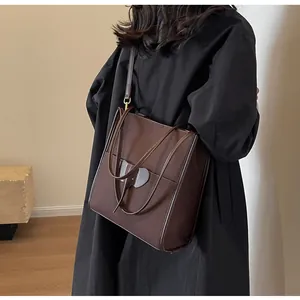 Detail of dark brown tote bag with elephant leather patch and adjustable strap