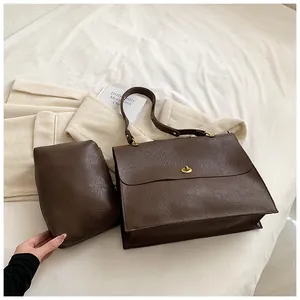 Detail of dark brown tote bag set with vintage textured leather and golden turn-lock