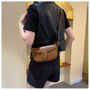Détail d'un sac besace marron vintage avec coutures fines et boucle en cuir élégante