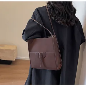 Detail of dark brown tote bag with 3D elephant pocket design and visible leather texture