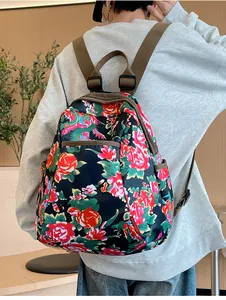Detail of backpack side pocket and durable nylon floral fabric with adjustable strap