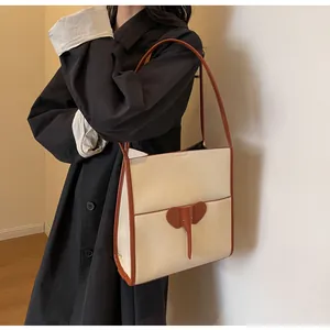 Detail view of large tote bag with elephant leather patch and caramel leather straps