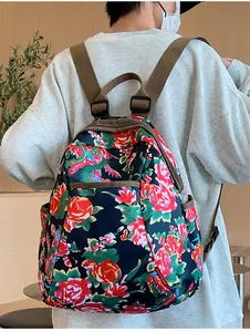 Rear view of a model wearing the backpack with traditional floral pattern and brown straps