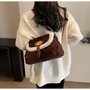 Detail of vintage plaid shoulder bag with faux fur trim and gold buckle on a model