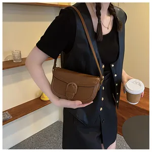Vue détaillée du sac besace vintage marron avec sa fermeture à boucle en D en cuir chic