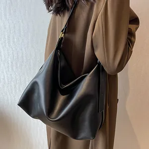 Detail van zwarte matte leren draagtas met verstelbare riem en matgouden fittingen