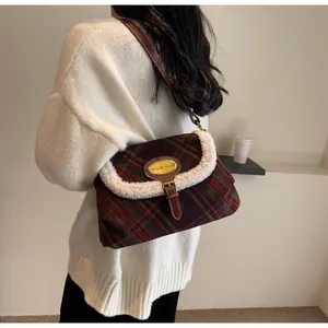Detail of vintage plaid shoulder bag with faux shearling trim and brown leather strap