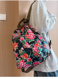 Detail view of ethnic floral canvas backpack featuring red peonies and adjustable straps
