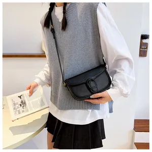 Sac bandoulière vintage noir porté par un mannequin pour référence de taille et style
