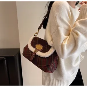 Detail of retro plaid wool shoulder bag with white fleece trim and gold brand plaque