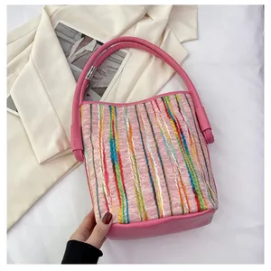 Details der farbigen Webstreifen und der rosa Lederbasis dieser Eimer-Handtasche
