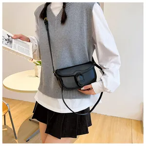 Détail d'un sac bandoulière vintage en cuir noir avec boucle ovale et sangle ajustable