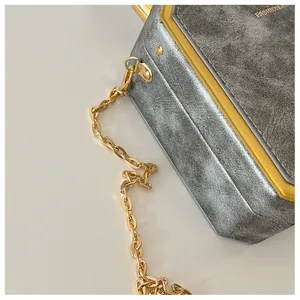 Detail of vintage gray chain bag with gold metal frame and textured finish