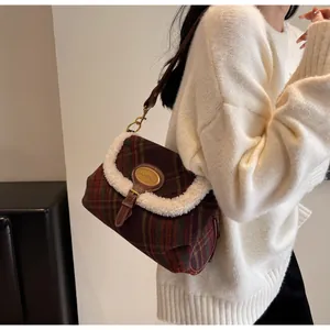 Detail of vintage red and green plaid shoulder bag with soft wool trim and golden logo