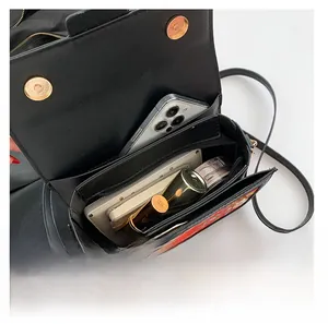 Internal layout of black crossbody bag showing large capacity for phone and makeup