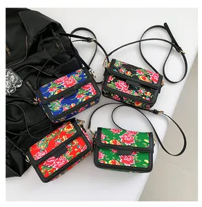 Top view of traditional floral pattern crossbody bags in red, blue, black, and green