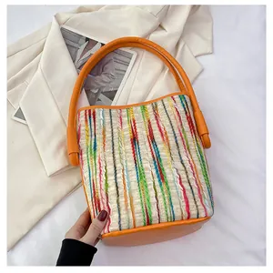 Detail der bunt gewebten Canvas-Beuteltasche mit leuchtend orangen Lederbesätzen