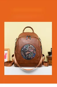 Detail of brown faux leather backpack featuring vintage elephant embroidery and texture