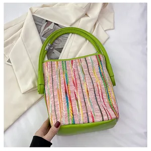 Detail der rosa Segeltuch-Beuteltasche mit bunten Streifen und grünen Griffen