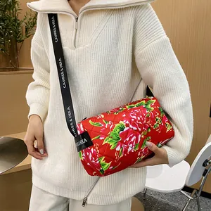 Floral quilted crossbody cylinder bag in red peony print with black nylon strap