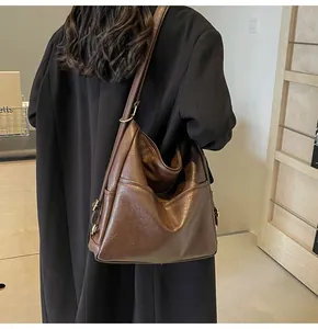 Detail of dark brown vintage leather tote bag with adjustable strap on model back