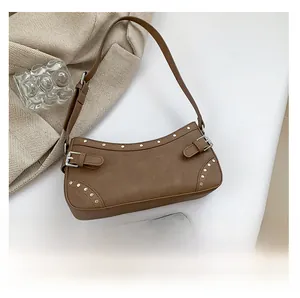 Vue de dessus d'un sac sous le bras marron vintage avec clous et smartphone pour la taille