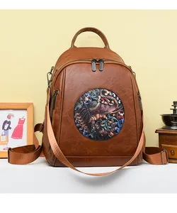 Detail of vintage brown PU leather backpack with elephant motif and metal zipper