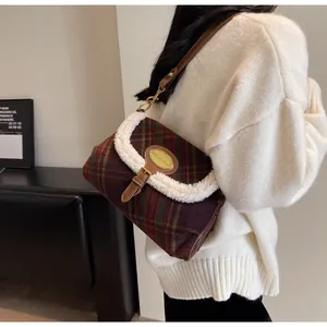 Detail of plaid shoulder bag with soft sherpa trim and elegant brown leather strap