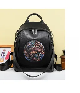 Detail of elegant black faux leather backpack featuring a vintage colorful elephant patch