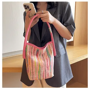 Detail der pinken Canvas-Beuteltasche mit bunten Webstreifen und langen Schulterriemen