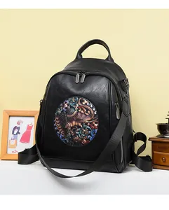 Detail of black faux leather backpack with vintage elephant embroidery and metal zipper