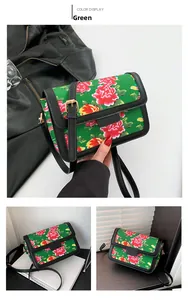 Detail view of the green Chinese floral crossbody bag featuring red peony patterns