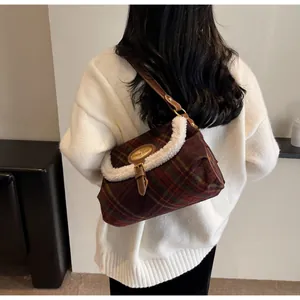 Detail of vintage plaid shoulder bag with soft faux fur trim and leather strap on model