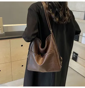 Macro shot of dark brown vintage bucket bag with metal buckle and soft leather texture