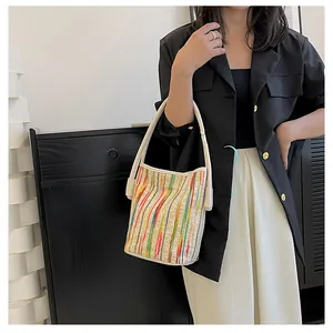 Detail der bunt gestreiften Canvas-Beuteltasche mit Stoffstruktur und Leder-Trageriemen