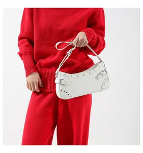 Sac sous l'aisselle en denim blanc avec rivets sur tenue rouge pour un look Y2K tendance